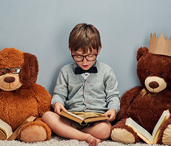 Kind mit Kinderbrille liest vor