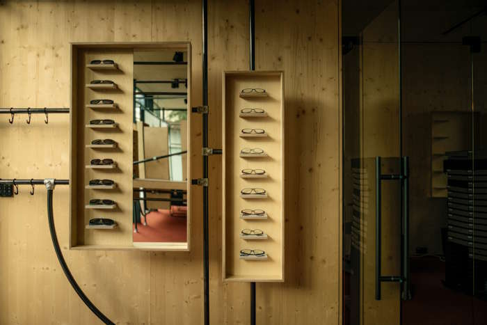 Moderne Holz-Inneneinrichtung mit nachhaltigen Brillenmodellen – Fokus auf soziale Nachhaltigkeit im Design.