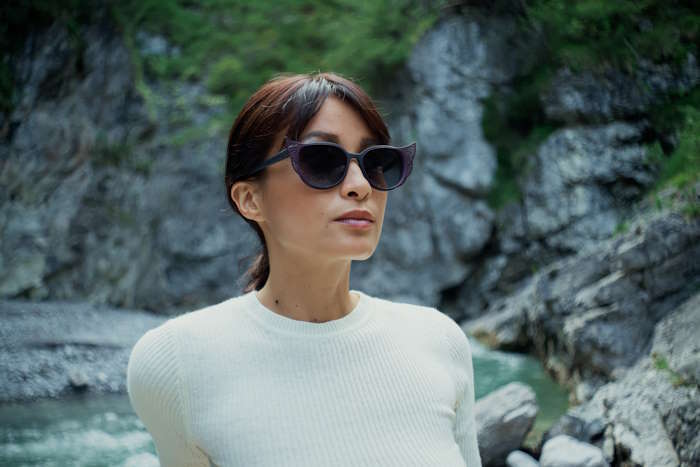 Frau mit modischer Sonnenbrille in Felsenschlucht – Tönung bei Sonnenbrillen