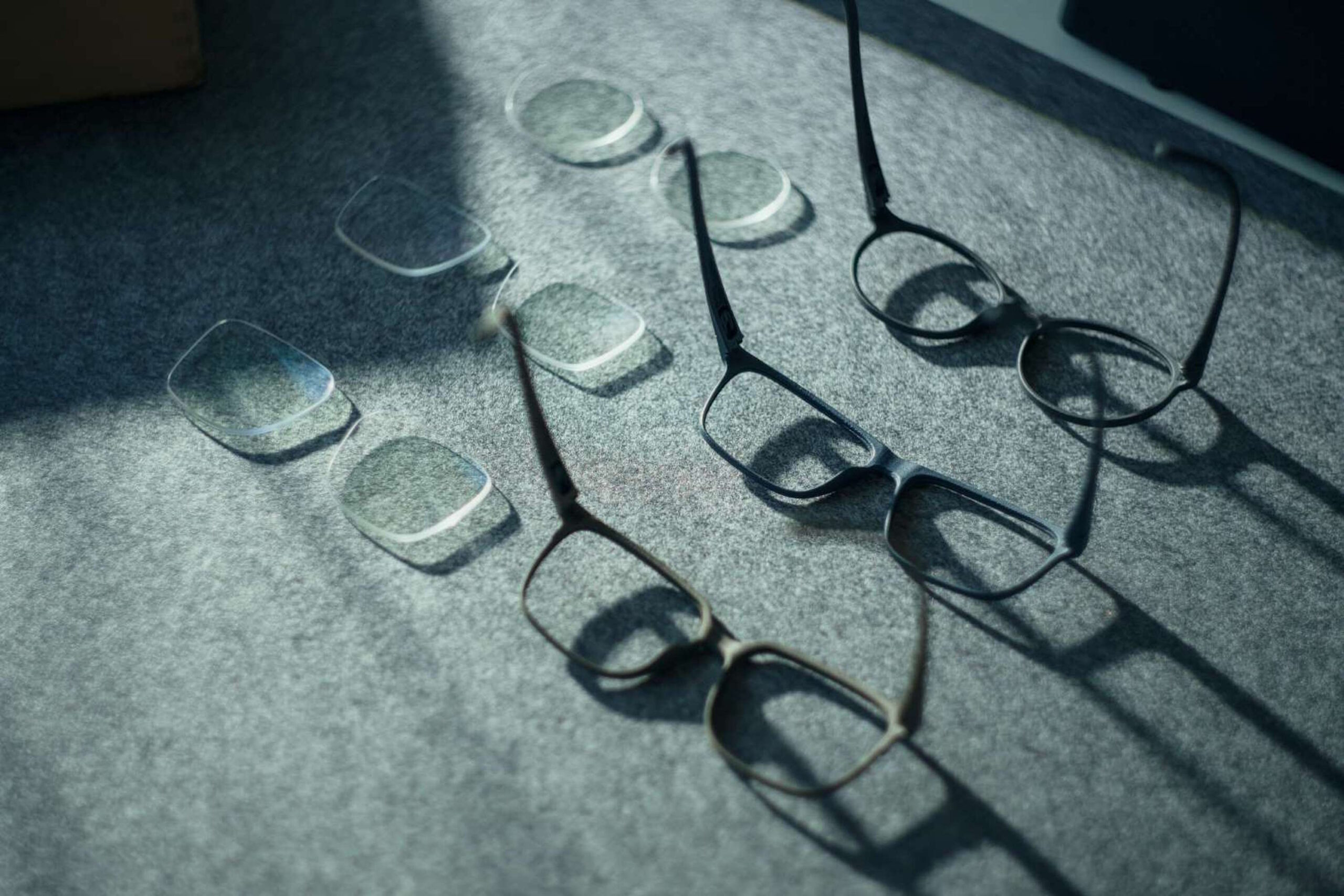 Brillen werfen Schatten auf eine Oberfläche, symbolisch für Sehprobleme bei Bindehautentzündung