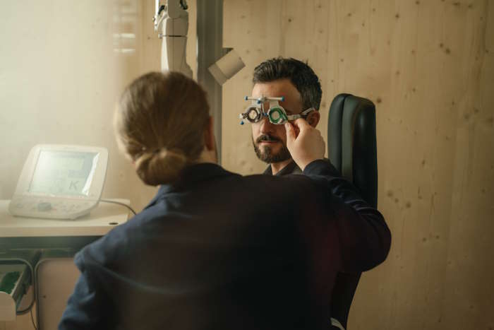 Ein Augenarzt führt eine Augenuntersuchung zu Schleimfäden im Auge durch.