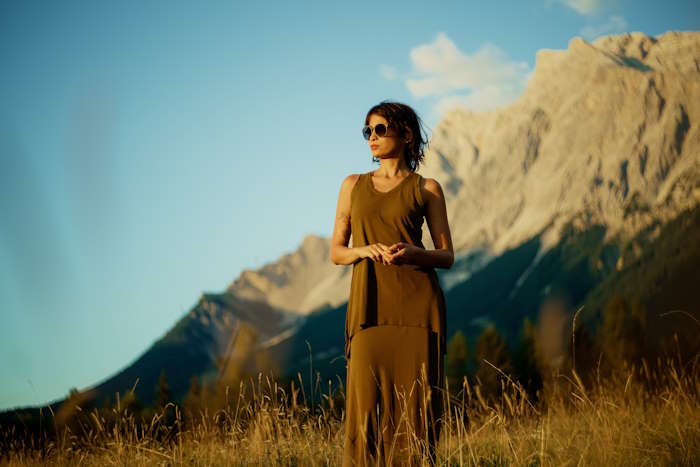 Frau mit Sonnenbrille in einem Bergfeld, perfekt für Brillen für den Urlaub