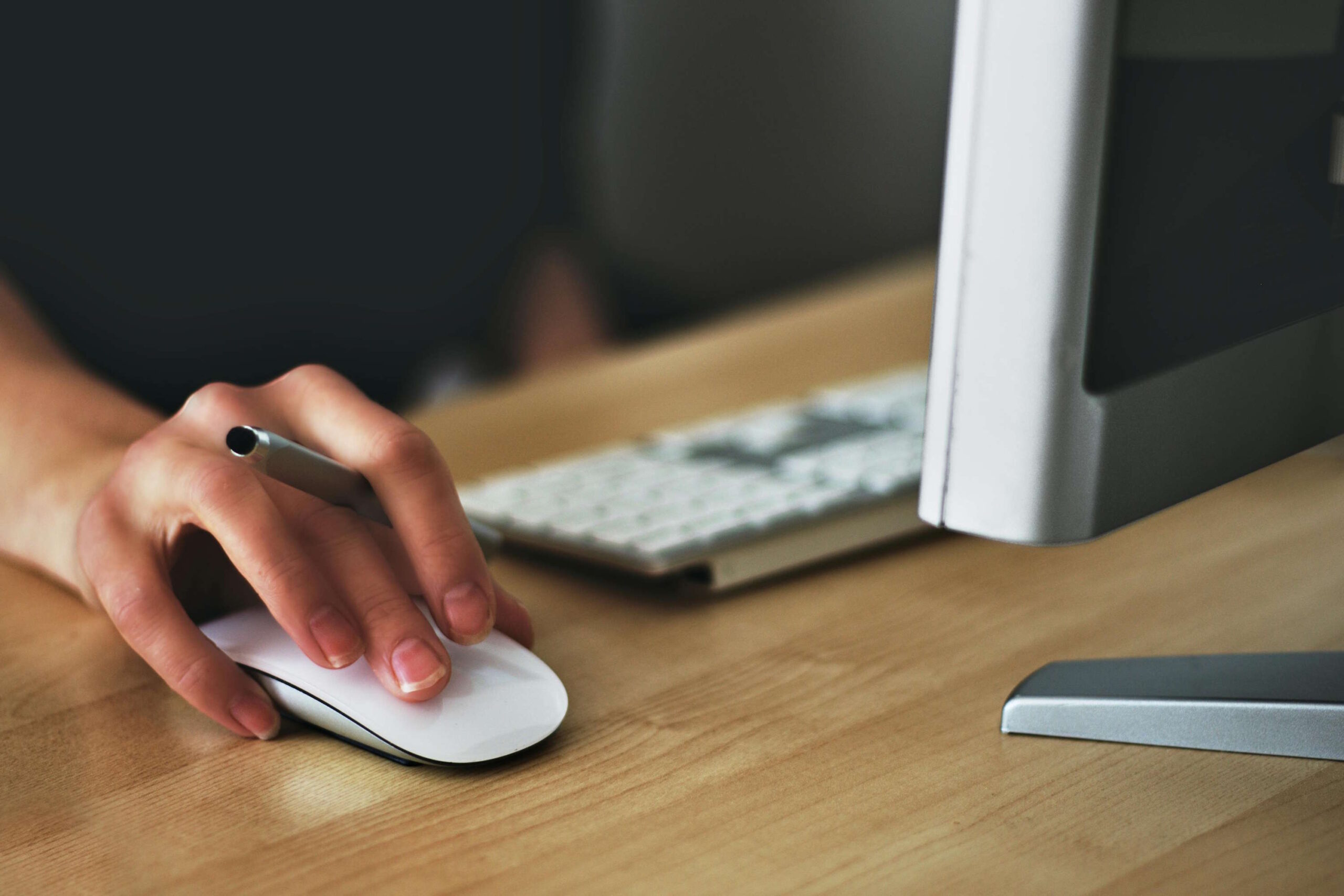 Hand mit Maus und Stift, symbolisch für Wellness Brillen im digitalen Alltag.