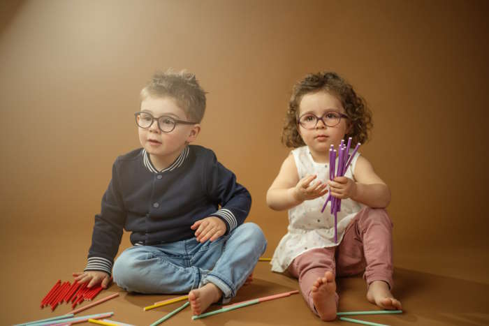 Zwei Kleinkinder mit Brillen und bunten Stiften – Wie entsteht eine Brille?