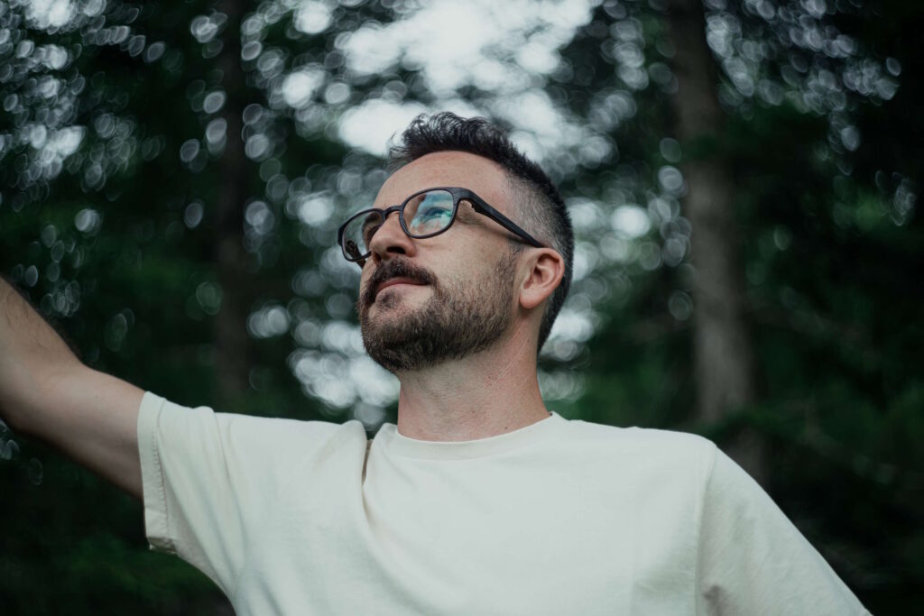 Brillenträger mit Bart | die perfekte Harmonie 5 Junger Brillenträger mit Bart schaut nach oben im Wald