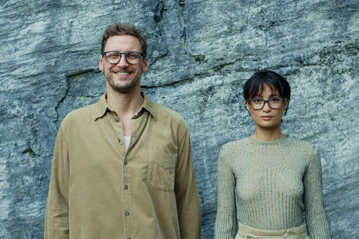 Mann und Frau mit Brille vor Steinwand – Welche Brille passt zu welcher Augenfarbe